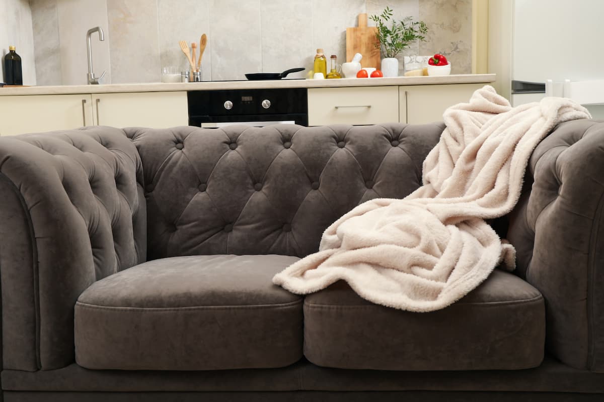 manta clara sobre o sofa escuro